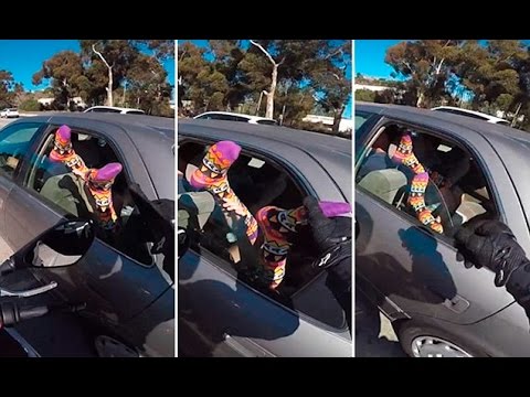 Motorcyclist squeeze the toes of a car rider with feet out the window